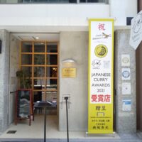 大阪市北区中津のカレー専門店に設置したタペストリーと真鍮エッチング看板